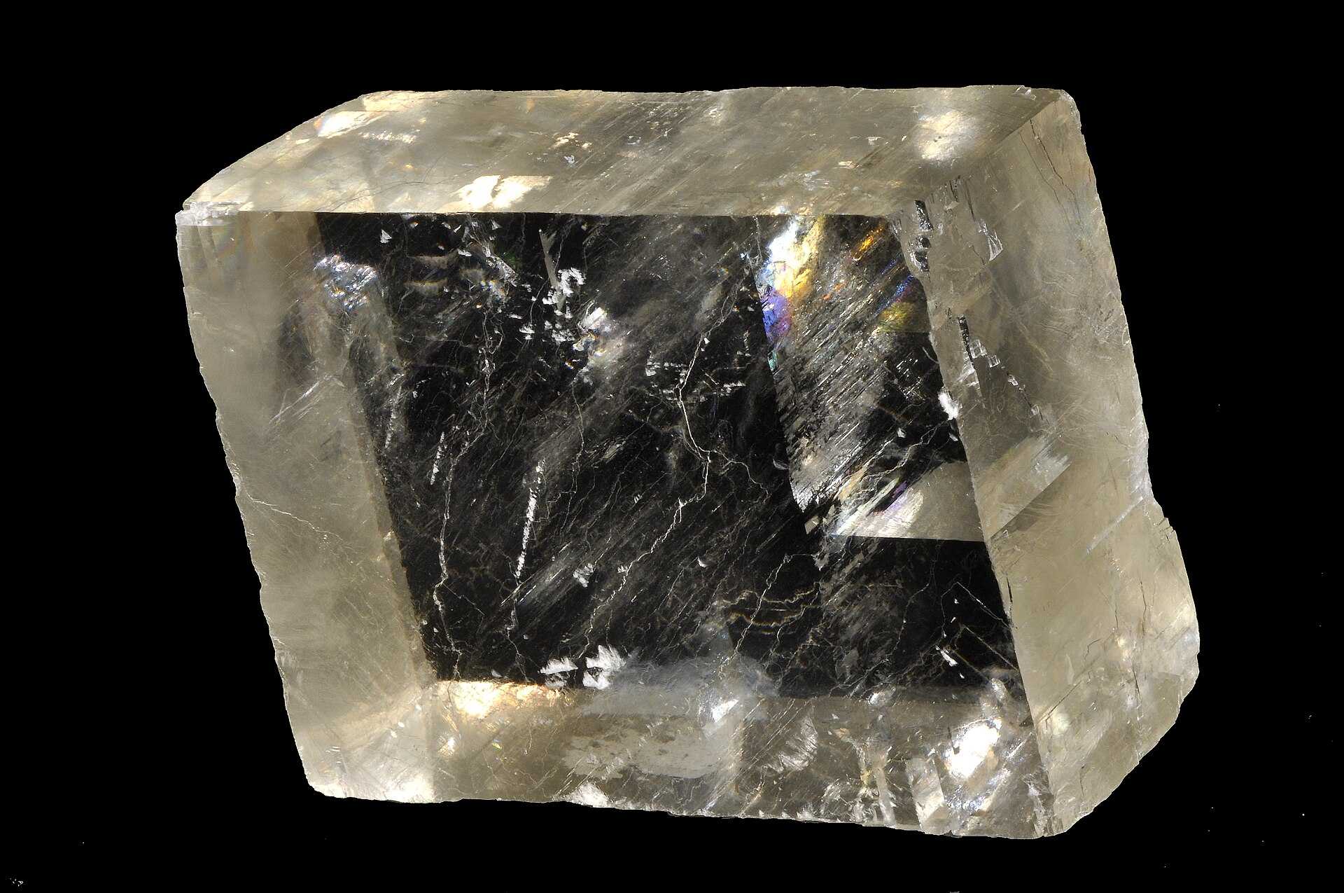 A cluster of translucent, blocky calcite crystals on a rock matrix